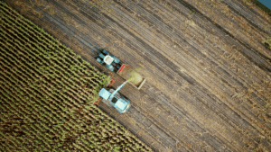 Aerial view of a tractor harvesting crops in a large field